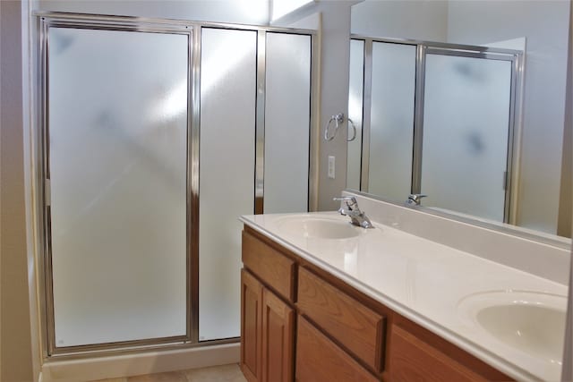 full bathroom with a sink, a shower stall, and double vanity