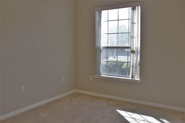 unfurnished room with light carpet and baseboards