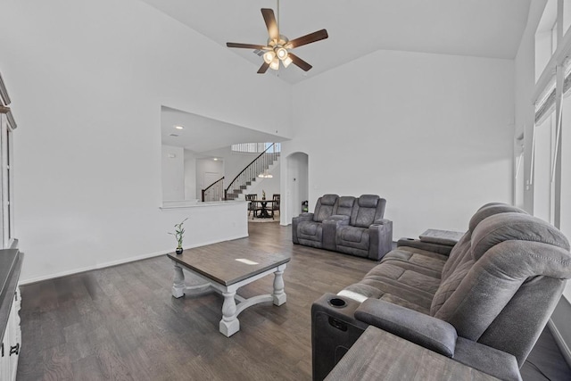 living room featuring arched walkways, a ceiling fan, wood finished floors, high vaulted ceiling, and stairs