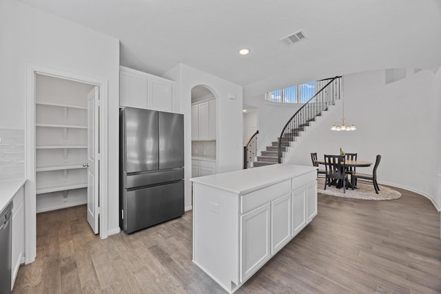 kitchen featuring visible vents, white cabinets, light wood-style flooring, stainless steel appliances, and light countertops