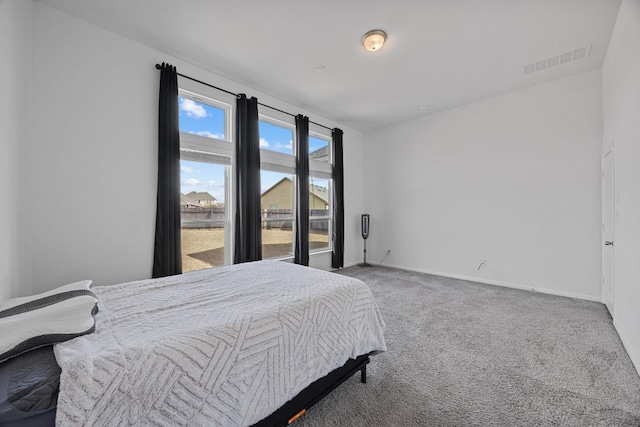 carpeted bedroom featuring baseboards and visible vents