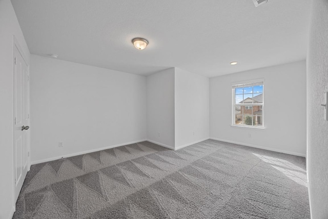 carpeted empty room featuring baseboards