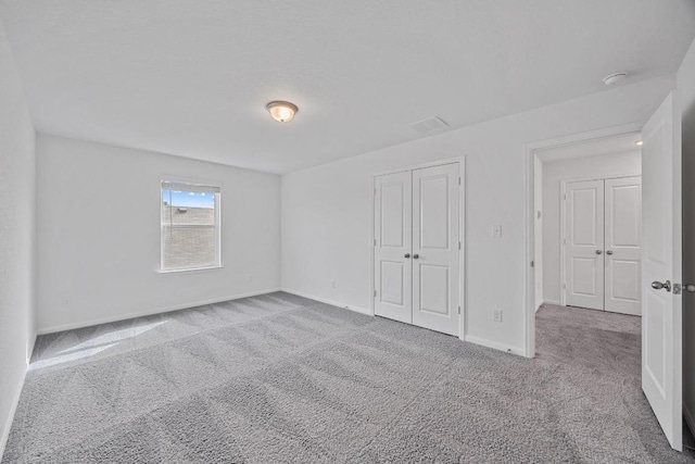 unfurnished bedroom featuring a closet, baseboards, and carpet flooring