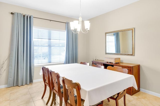 dining area with baseboards, a notable chandelier, and light tile patterned flooring