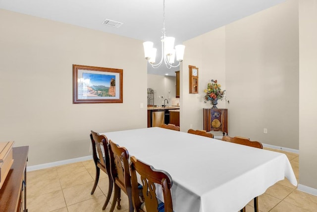 dining room featuring light tile patterned floors, baseboards, visible vents, and a chandelier