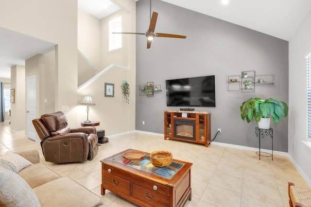 living room featuring baseboards, high vaulted ceiling, light tile patterned flooring, and a ceiling fan