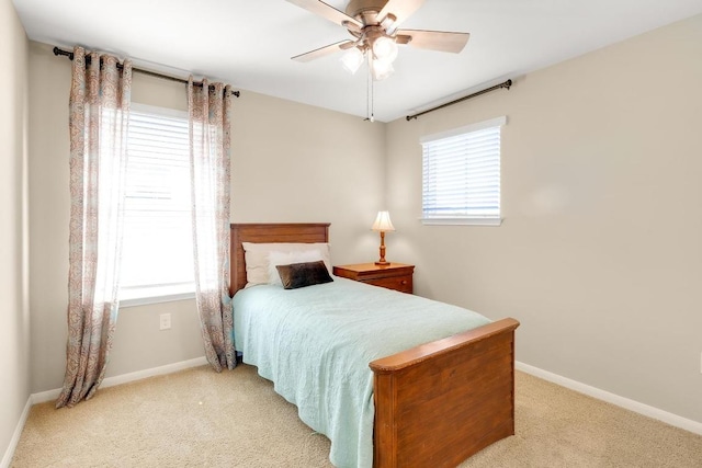 bedroom with light carpet, multiple windows, and baseboards