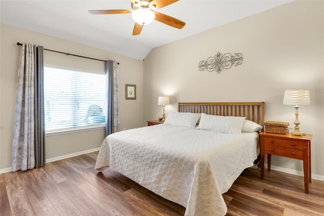 bedroom with lofted ceiling, wood finished floors, and baseboards