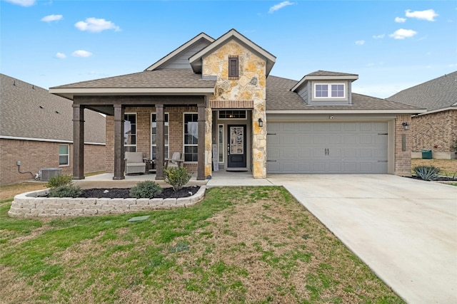 traditional-style house featuring concrete driveway, a garage, cooling unit, stone siding, and a front lawn