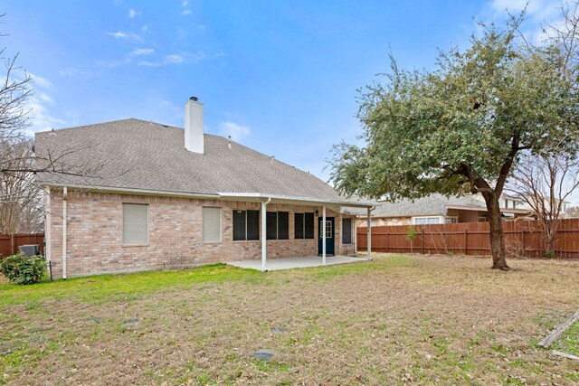 back of property with brick siding, a fenced backyard, and a patio