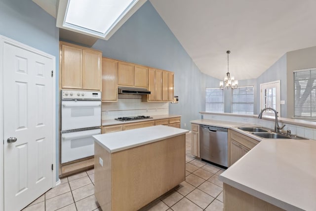 kitchen featuring white double oven, under cabinet range hood, a sink, stainless steel dishwasher, and light brown cabinetry