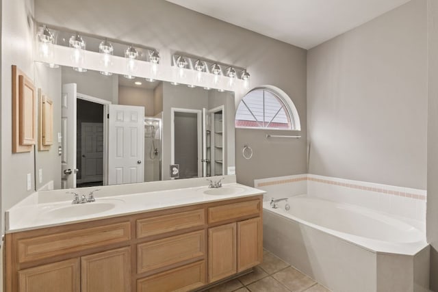 full bathroom featuring double vanity, a garden tub, a sink, and tile patterned floors