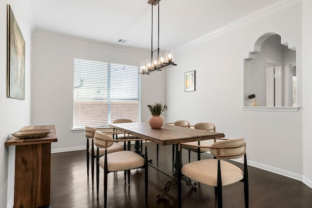 dining room with crown molding, baseboards, dark wood-type flooring, and visible vents