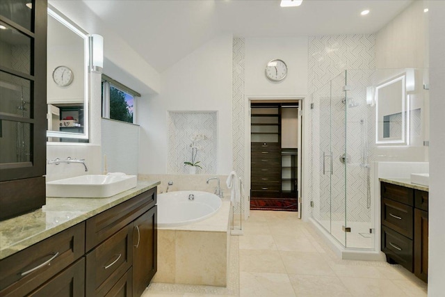 5908 Taylor Draper Cv, Austin, TX 78759 - bathroom with vanity, a stall shower, a garden tub, tile patterned flooring, and vaulted ceiling