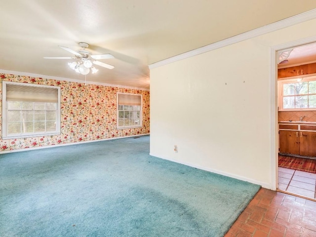 spare room with wallpapered walls, crown molding, baseboards, and ceiling fan