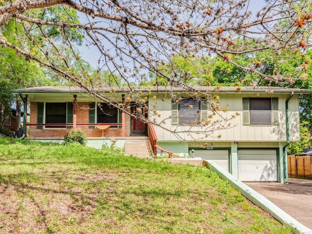 ranch-style house featuring a front yard, brick siding, driveway, and an attached garage