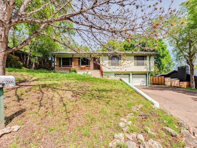 ranch-style home featuring a garage, driveway, and fence