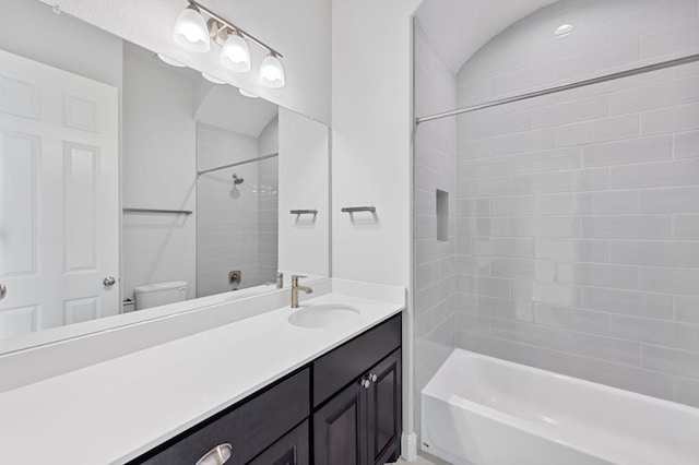 bathroom featuring washtub / shower combination, vanity, and toilet