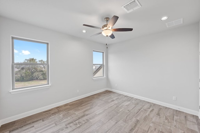 spare room with light wood-style floors, baseboards, visible vents, and recessed lighting