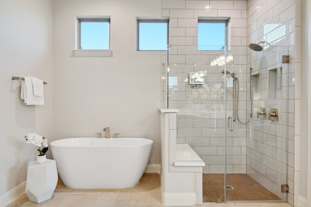 full bathroom with a stall shower, tile patterned flooring, a healthy amount of sunlight, and a freestanding bath