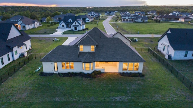 exterior space featuring a fenced backyard, a residential view, and roof with shingles