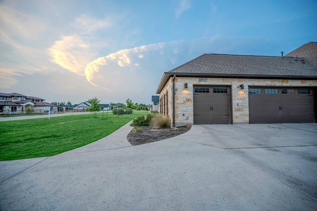 227 Dally Ct, Dripping Springs, TX 78620 - view of side of property with a yard, concrete driveway, stone siding, and a shingled roof
