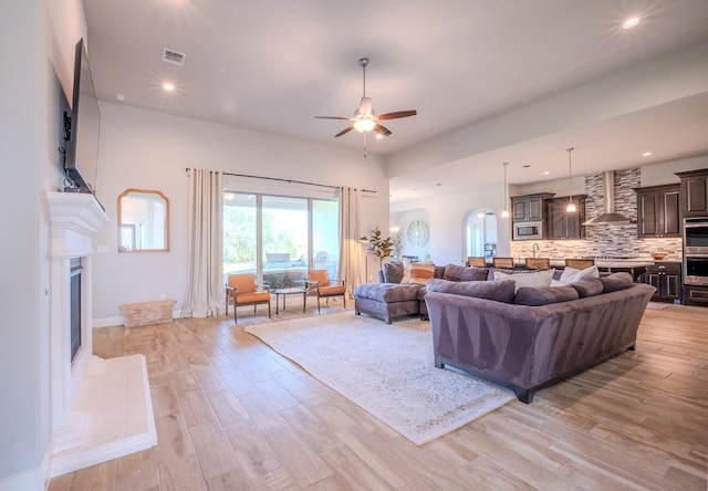 227 Dally Ct, Dripping Springs, TX 78620 - living area with light wood-style floors, a ceiling fan, a fireplace with raised hearth, recessed lighting, and baseboards