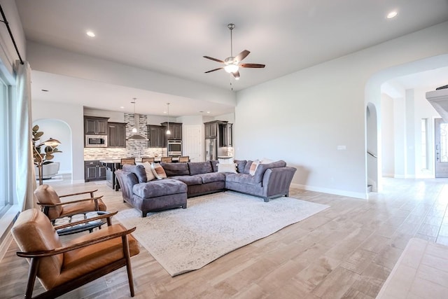 227 Dally Ct, Dripping Springs, TX 78620 - living room featuring ceiling fan, arched walkways, baseboards, recessed lighting, and light wood-type flooring