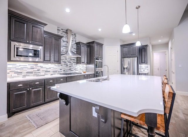 227 Dally Ct, Dripping Springs, TX 78620 - kitchen with appliances with stainless steel finishes, wall chimney exhaust hood, backsplash, a sink, and a large island with sink