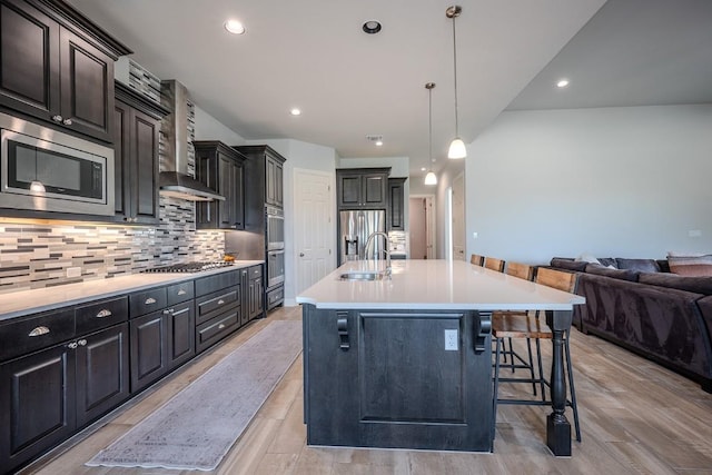 227 Dally Ct, Dripping Springs, TX 78620 - kitchen with stainless steel appliances, a sink, open floor plan, a kitchen bar, and tasteful backsplash