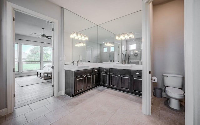 227 Dally Ct, Dripping Springs, TX 78620 - bathroom with double vanity, a ceiling fan, toilet, tile patterned floors, and baseboards
