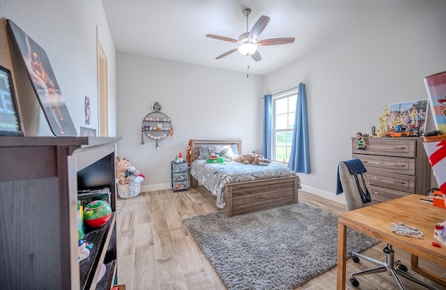 227 Dally Ct, Dripping Springs, TX 78620 - bedroom with an office area, light wood finished floors, baseboards, and a ceiling fan