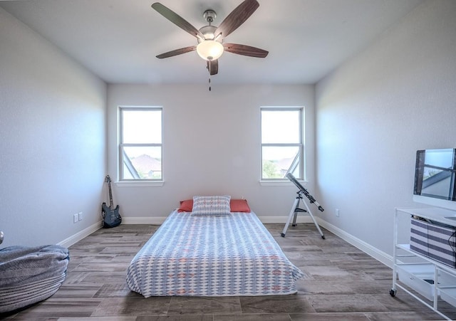 227 Dally Ct, Dripping Springs, TX 78620 - bedroom with multiple windows, baseboards, a ceiling fan, and wood finished floors