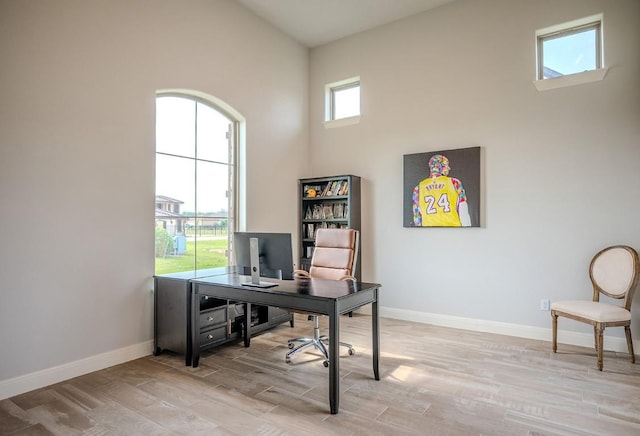 227 Dally Ct, Dripping Springs, TX 78620 - office with light wood-style floors, a towering ceiling, and baseboards