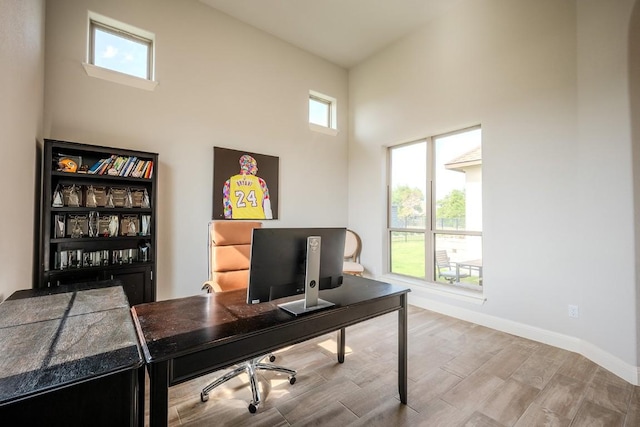 227 Dally Ct, Dripping Springs, TX 78620 - office area featuring wood finished floors, baseboards, and a towering ceiling
