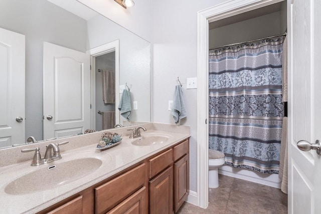 bathroom with tile patterned flooring, a sink, toilet, and double vanity