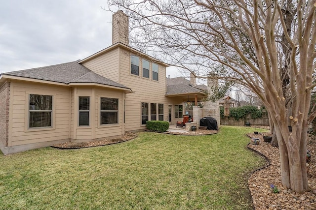 back of property featuring roof with shingles, a chimney, a lawn, a patio area, and fence