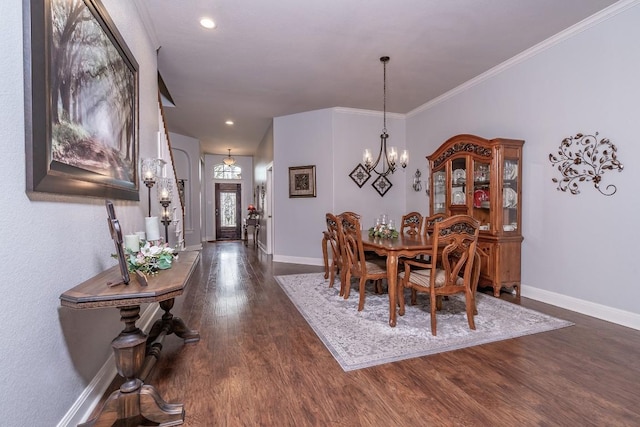 dining area with crown molding, dark wood finished floors, a notable chandelier, and baseboards