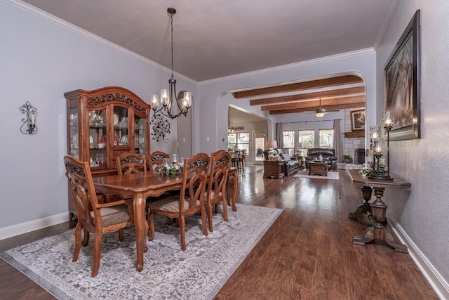 dining room with arched walkways, dark wood-type flooring, and crown molding