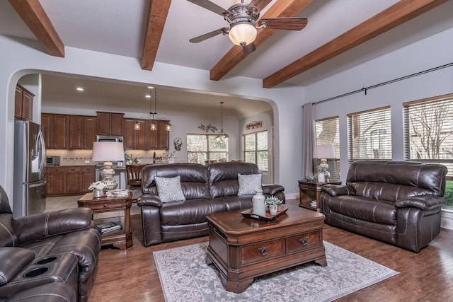 living room featuring arched walkways, a ceiling fan, wood finished floors, beam ceiling, and recessed lighting