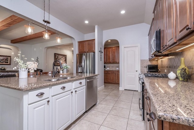 kitchen with a center island with sink, light tile patterned floors, backsplash, appliances with stainless steel finishes, and a sink