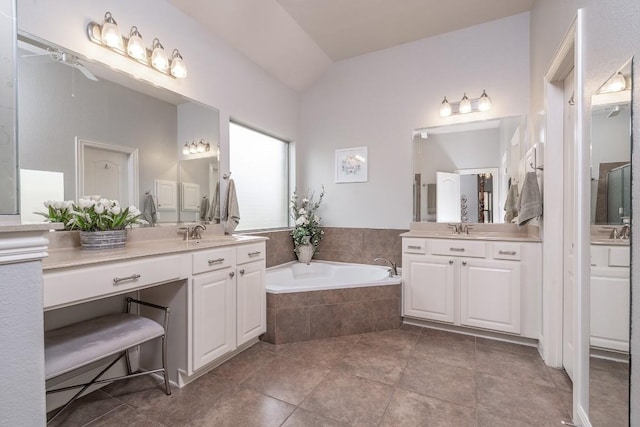 bathroom with a bath, two vanities, and a sink