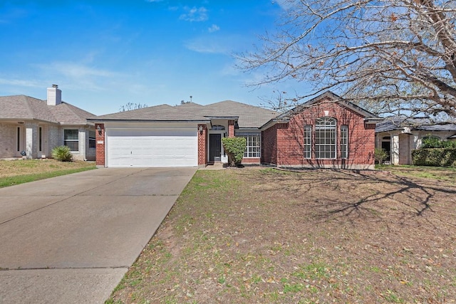 single story home with driveway, brick siding, and an attached garage