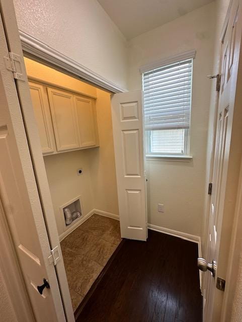 laundry room featuring cabinet space, baseboards, dark wood-type flooring, and electric dryer hookup