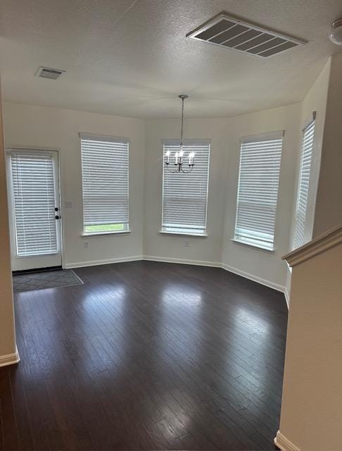 unfurnished dining area featuring dark wood-type flooring, visible vents, and baseboards