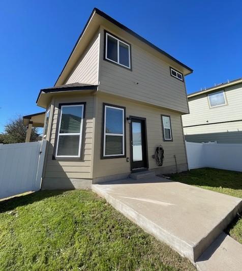 back of house featuring a yard, fence, and a patio