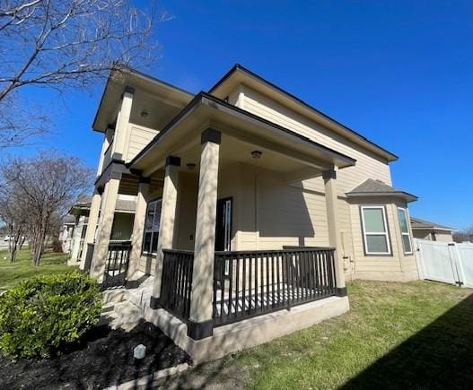 view of side of home featuring fence and a lawn