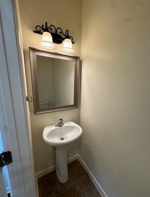 bathroom with baseboards, a sink, and tile patterned floors