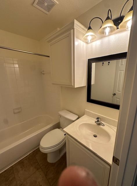 full bathroom with shower / bath combination, visible vents, toilet, tile patterned flooring, and vanity