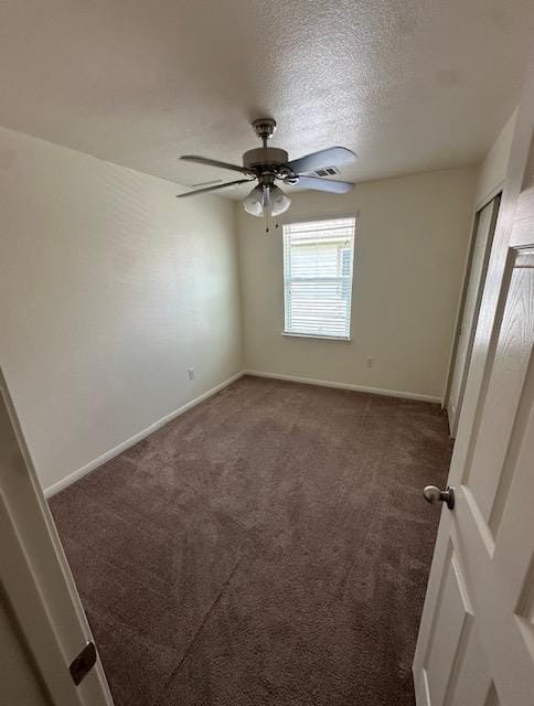 unfurnished bedroom with carpet flooring, ceiling fan, a textured ceiling, and baseboards